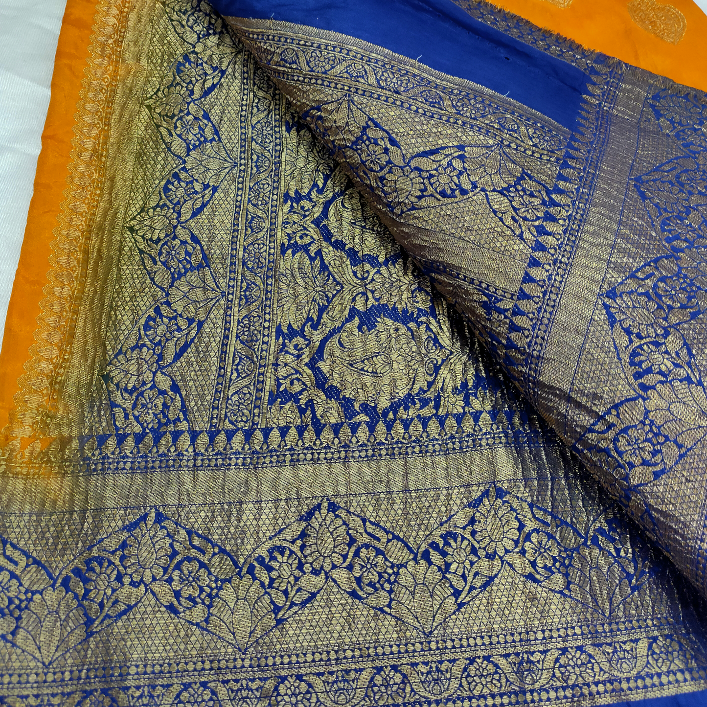 Close-up of a fabric with blue and gold patterns on an orange background